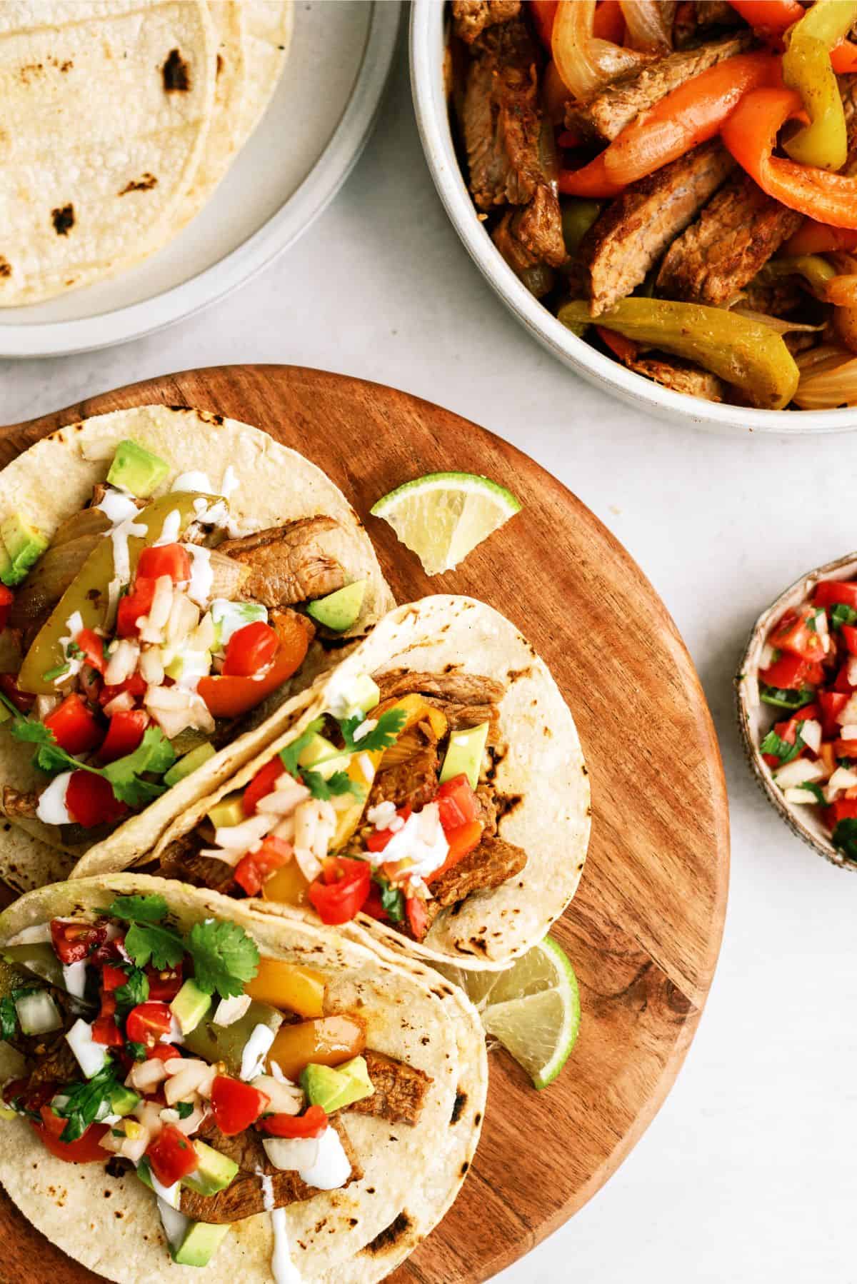 Instant Pot Steak Fajitas on a cutting board with toppings