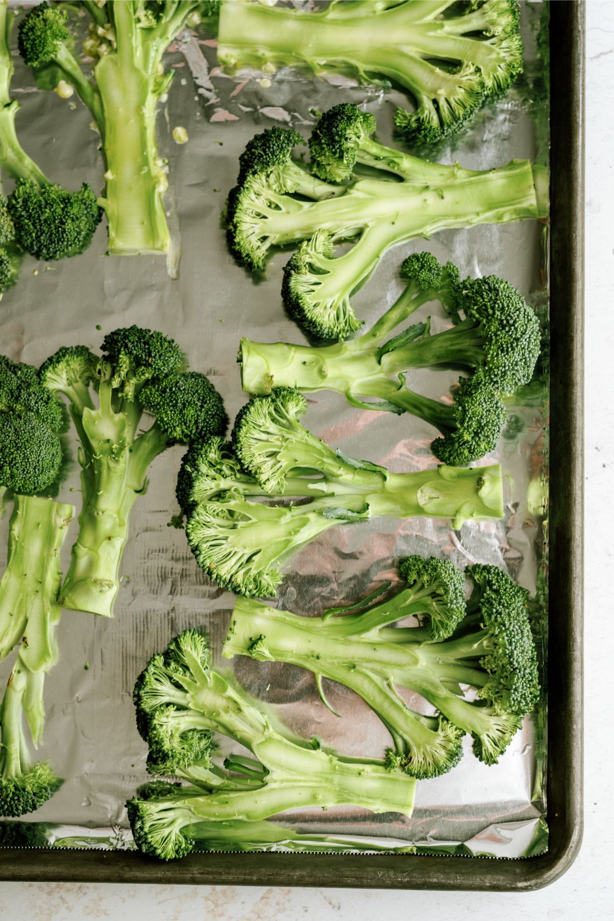 Sliced broccoli on a baking sheet