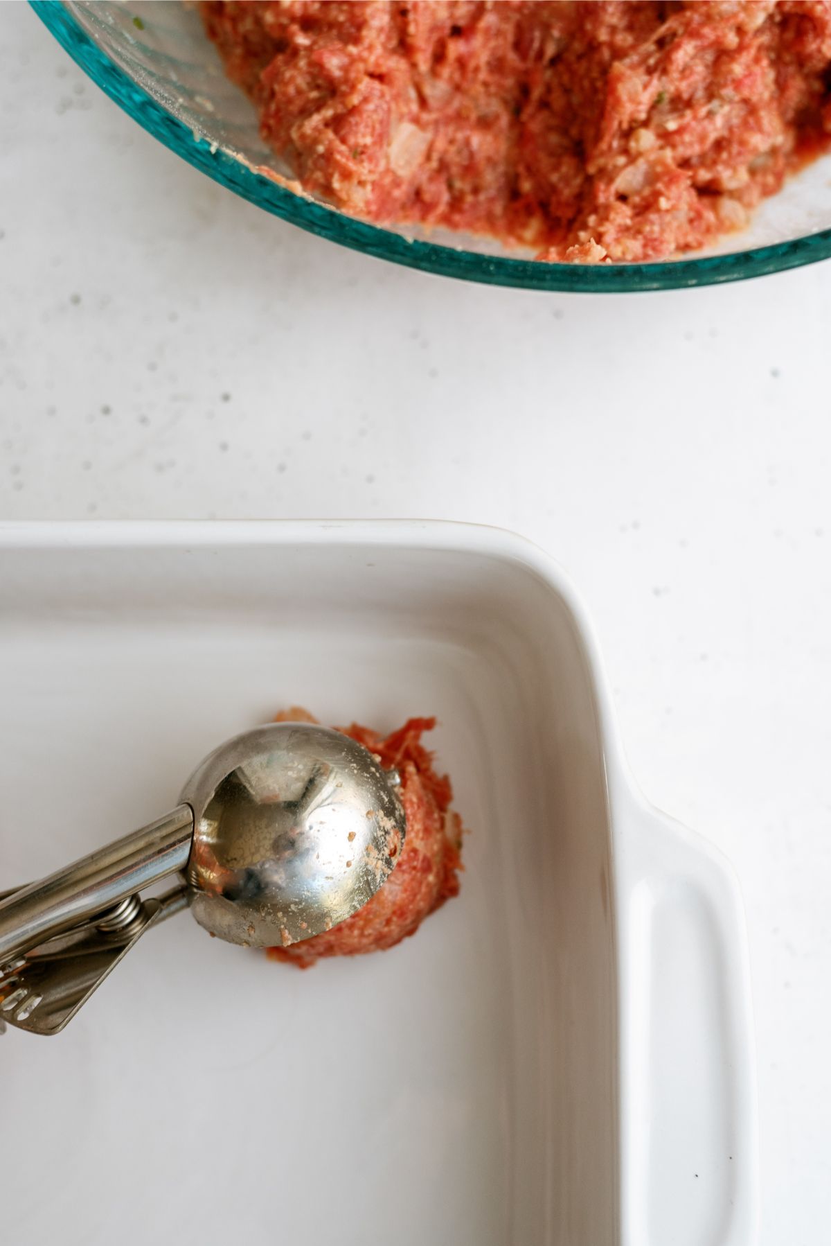 Scooping out meatballs with a cookie scoop