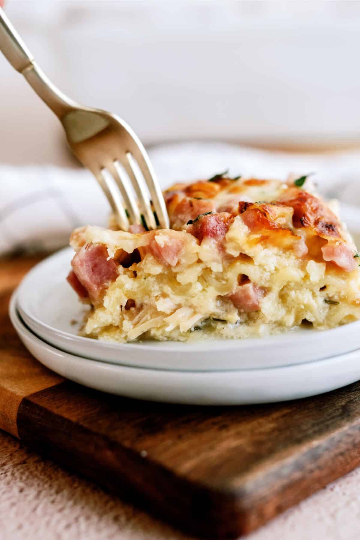 A serving of Chicken Cordon Bleu Lasagna on a plate with a fork