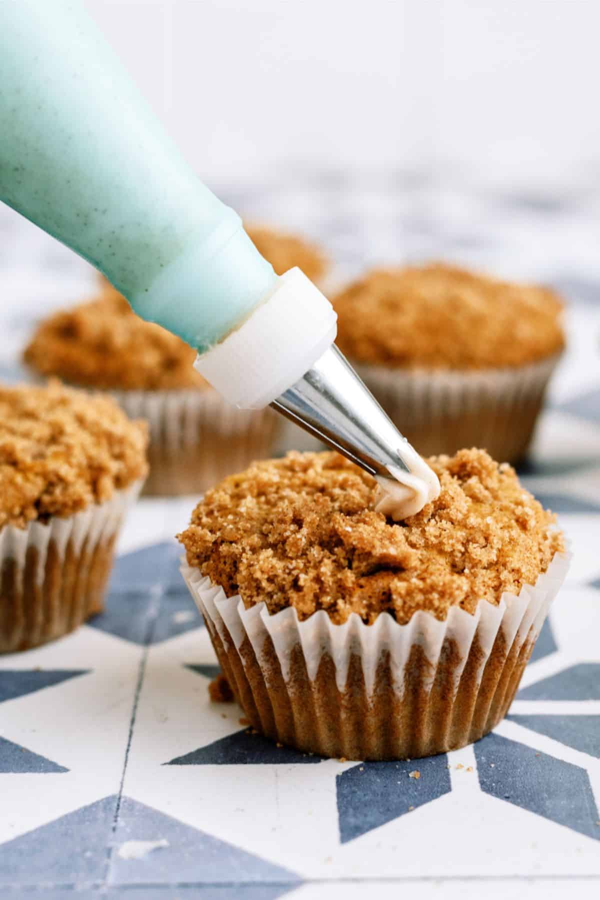 Frosting piped on Copycat Disneyland Pumpkin Muffins