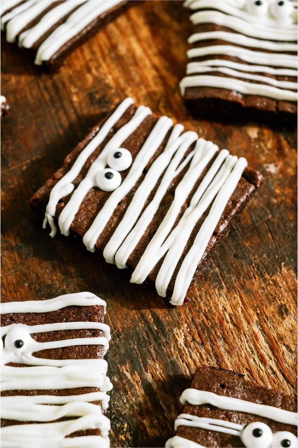 Close up of Halloween Mummy Brownie turned sideways on a wooden background.