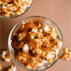 A cup of caramel popcorn with homemade caramel drizzled on top.