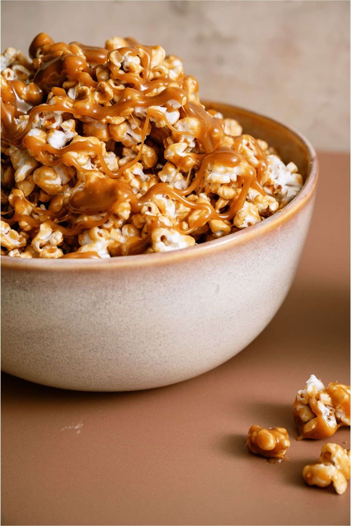 A bowl of Homemade Caramel Popcorn on a wooden background.
