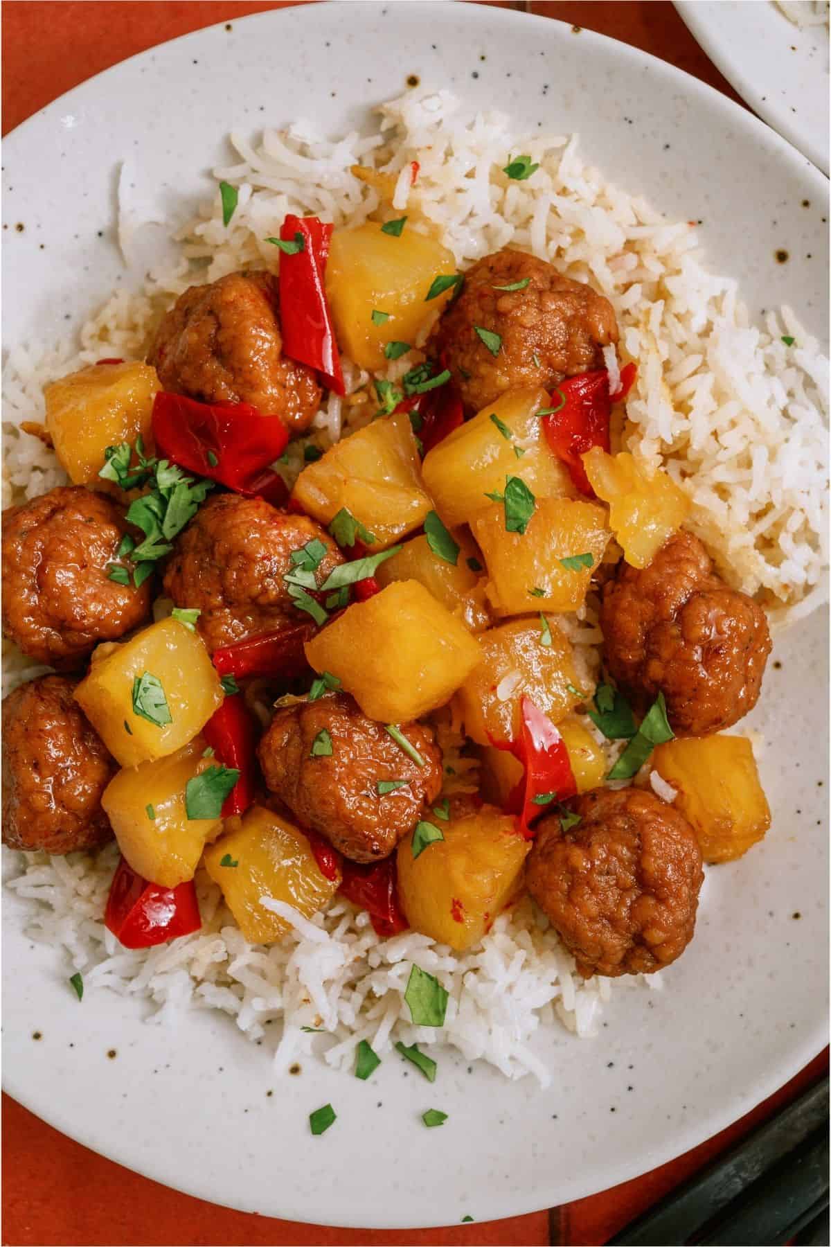 A serving of Instant Pot Hawaiian Meatballs over rice.