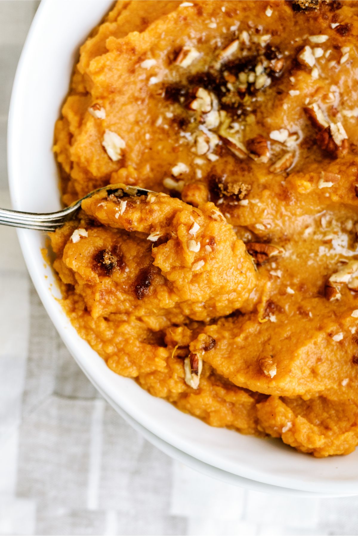 Close up of Mashed Sweet Potatoes in a bowl with a spoon