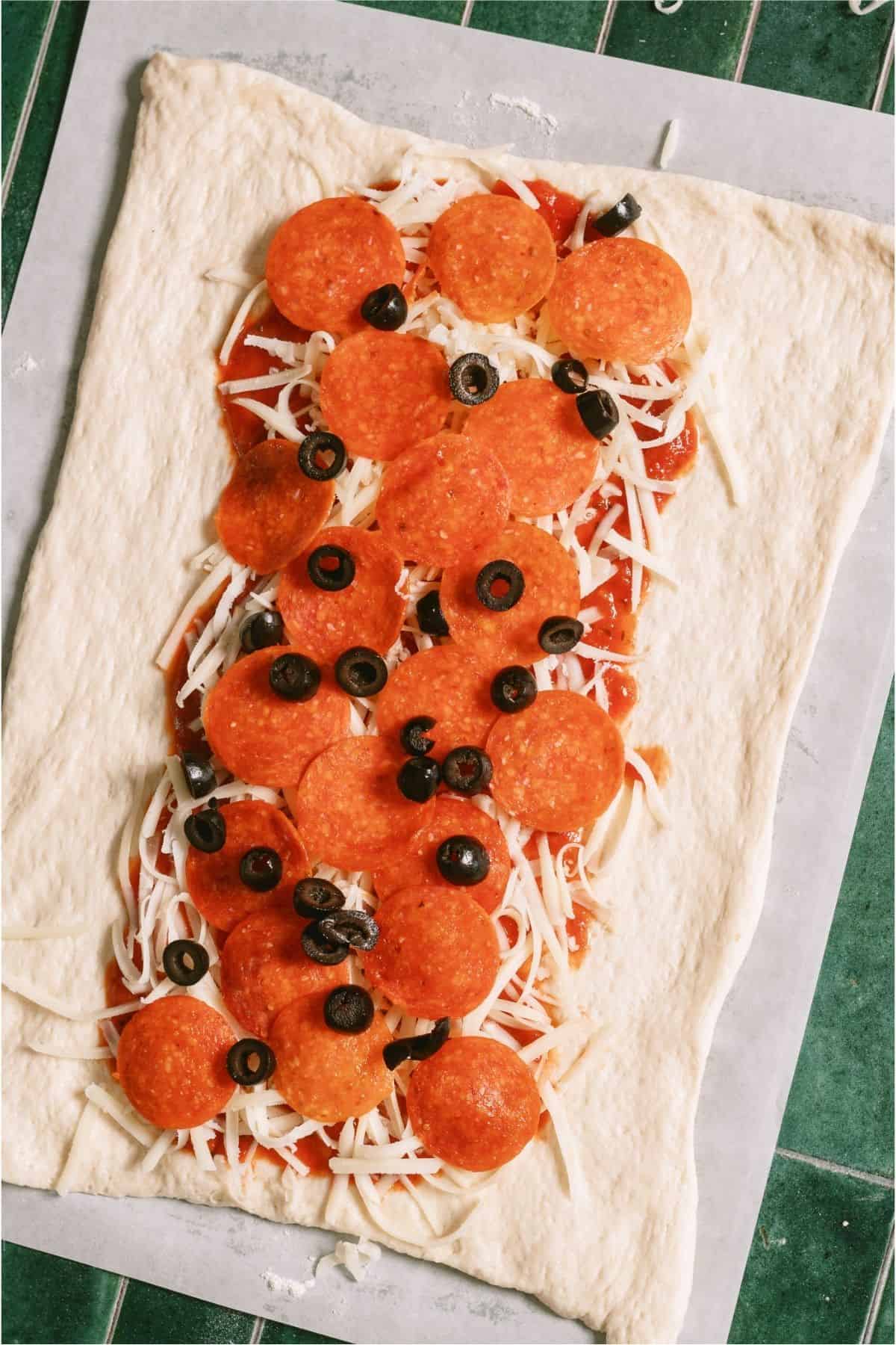 Toppings on top of cheese and sauce on pizza dough.
