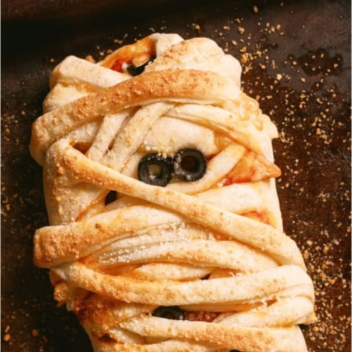 Top view of Mummy Pizza Braid on a dark background.