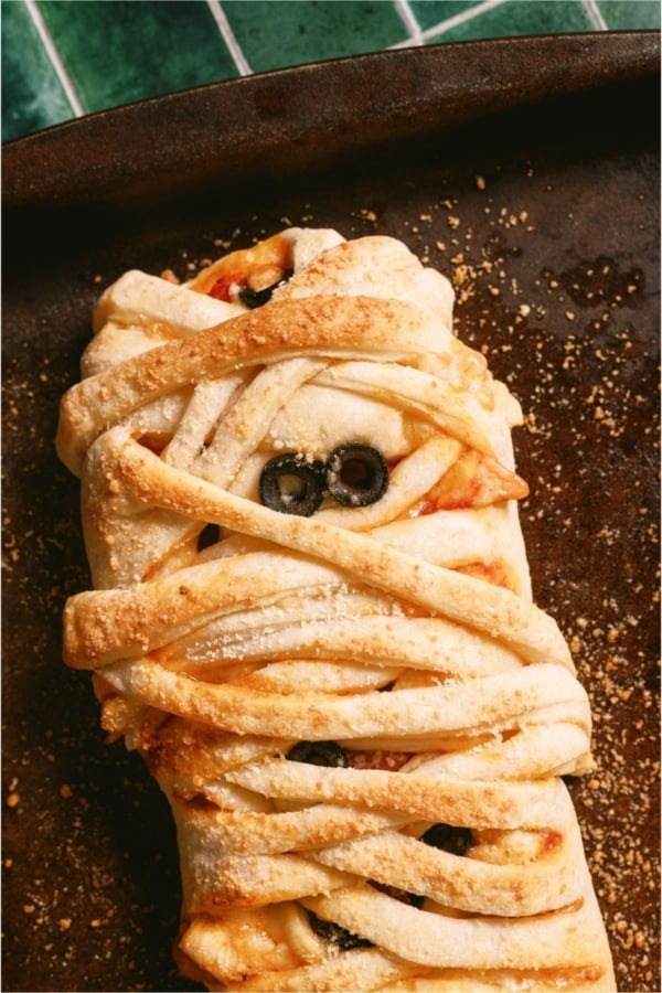 Top view of Mummy Pizza Braid on a dark background.