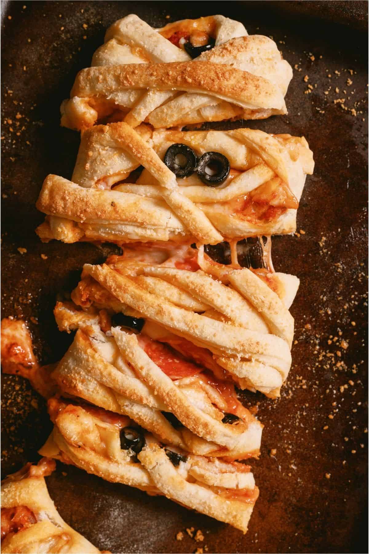 Mummy Pizza Braid on a sheet pan sliced.