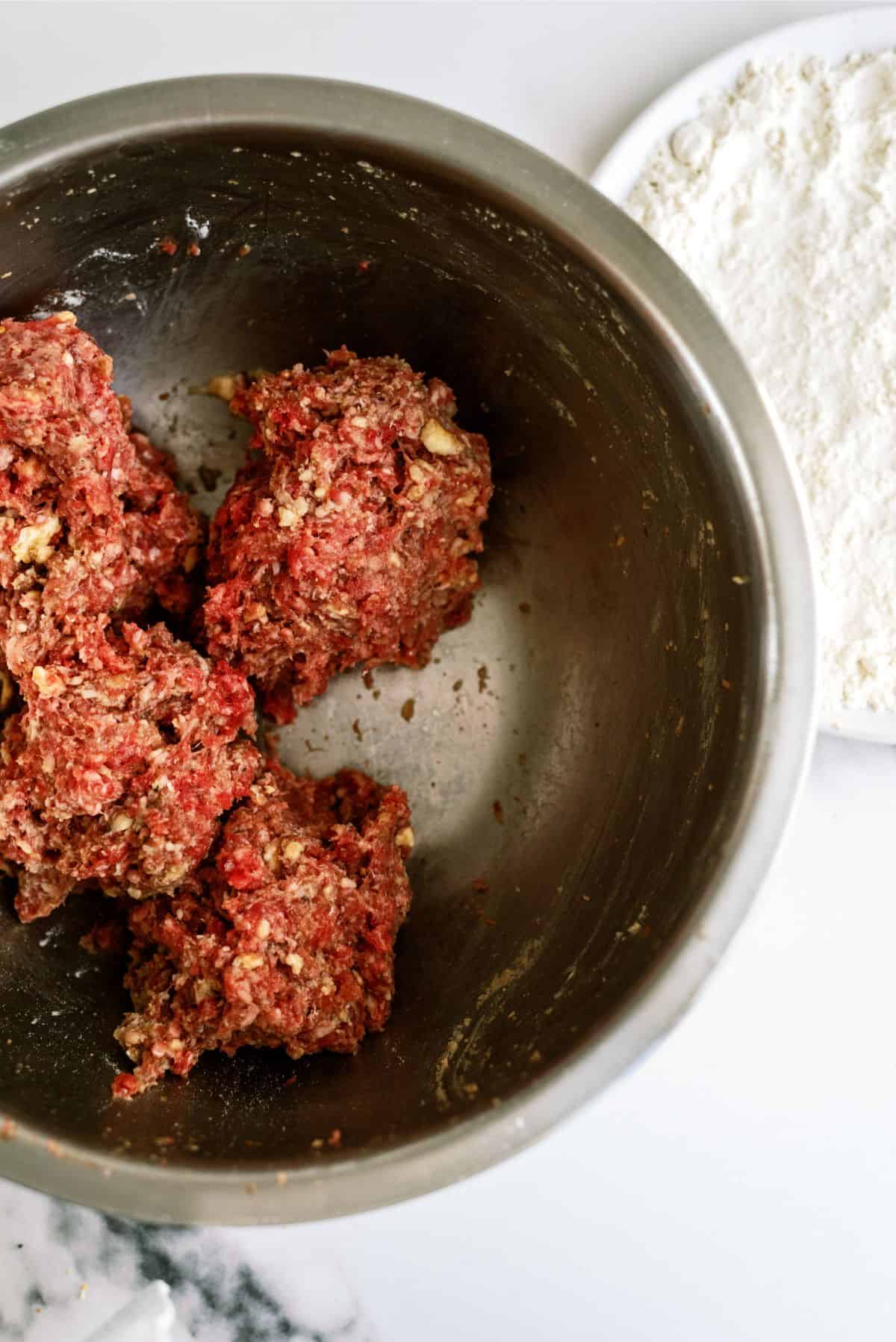 Ground beef, crackers and seasonings mixed together in a large mixing bowl