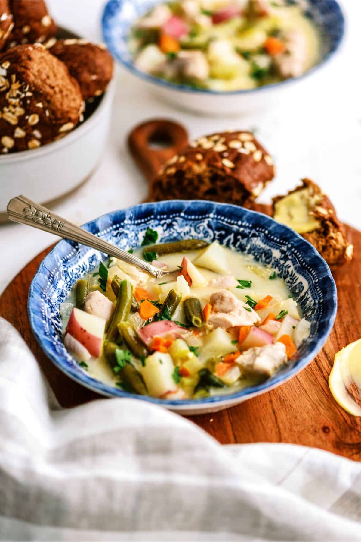 A bowl of Slow Cooker Creamy Chicken Stew with a side of bread