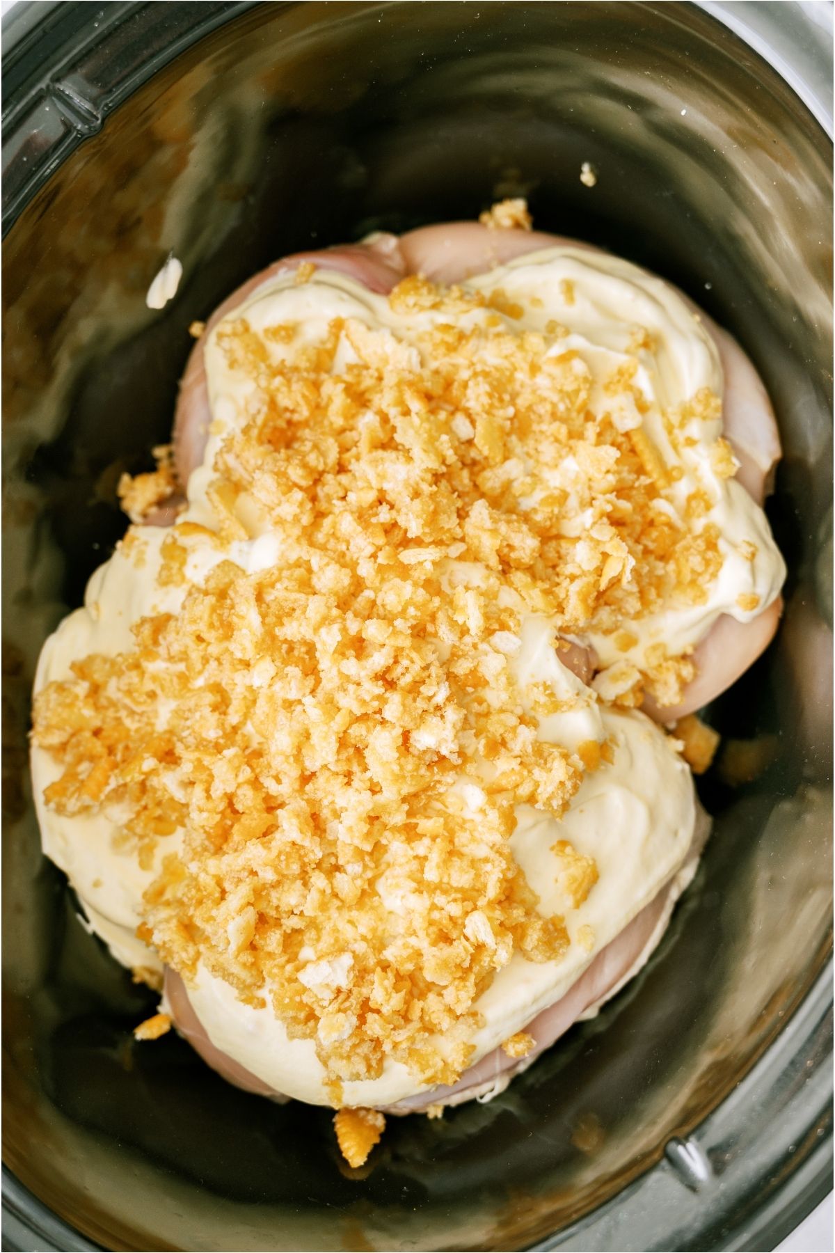Crushed ritz crackers on top of chicken in slow cooker.