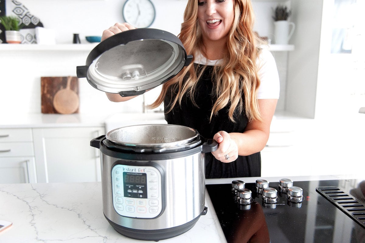 woman checking on cooked food in the instant pot