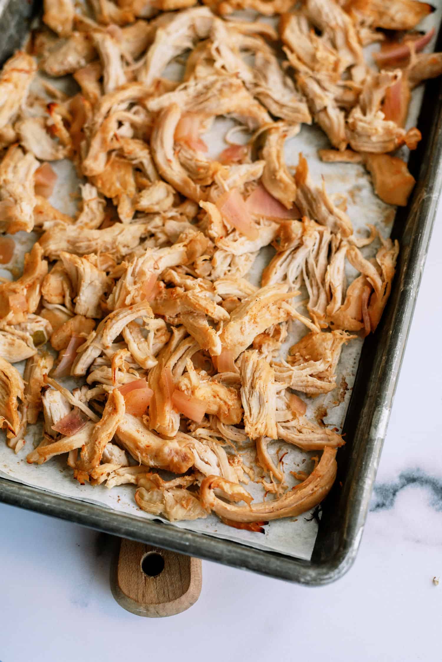 Shredded chicken on a baking sheet