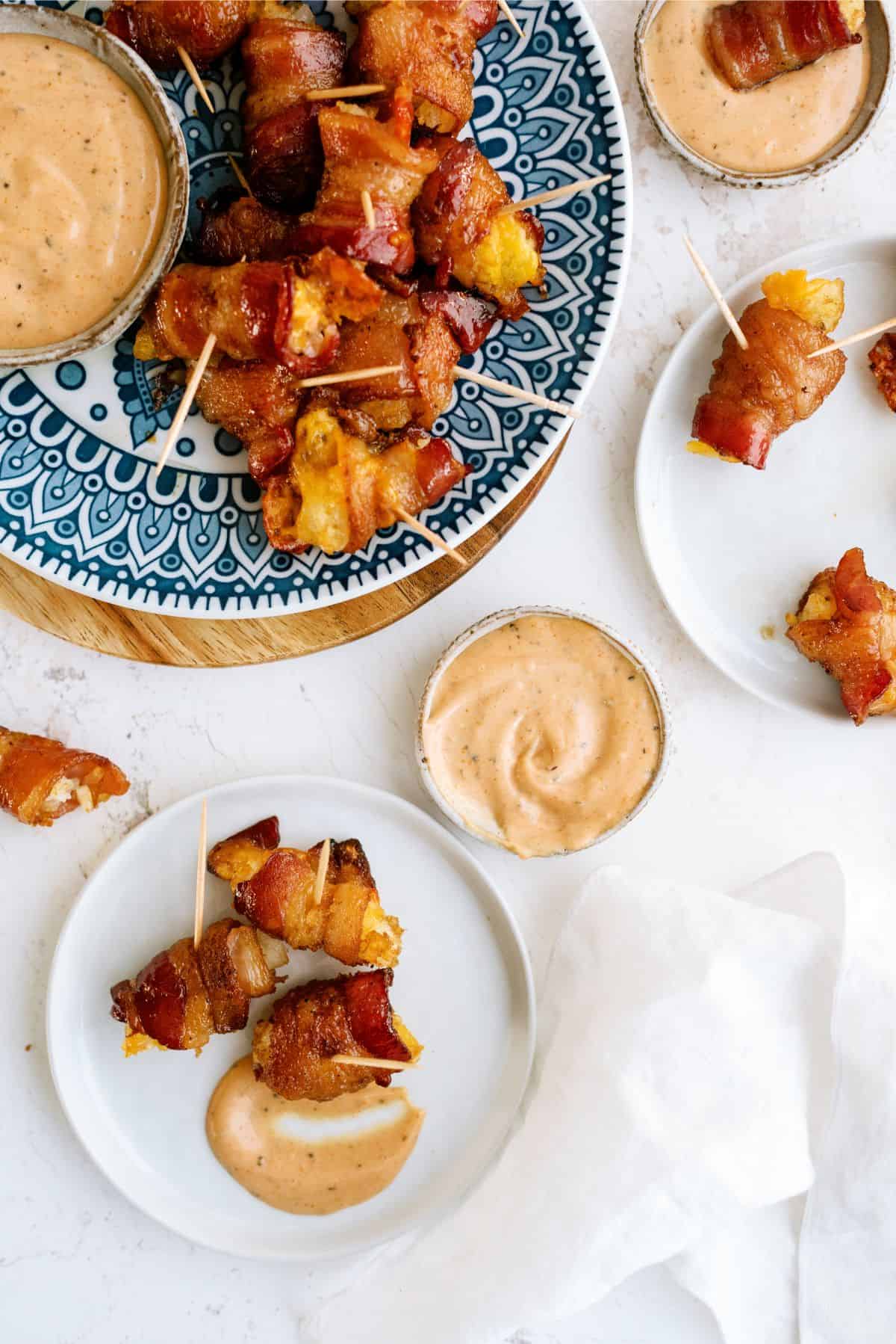 Bacon Wrapped Tater Tots with Cheese on a plate with sauce