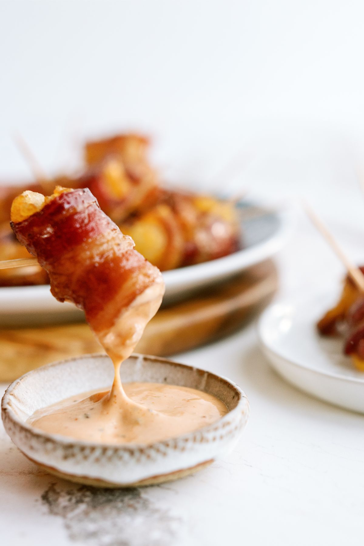 Bacon Wrapped Tater Tots with Cheese dipped in special sauce