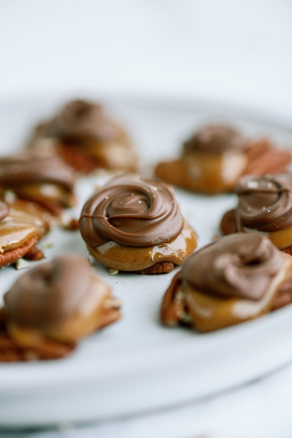 Chocolate Caramel Pecan Turtles on a serving plate.