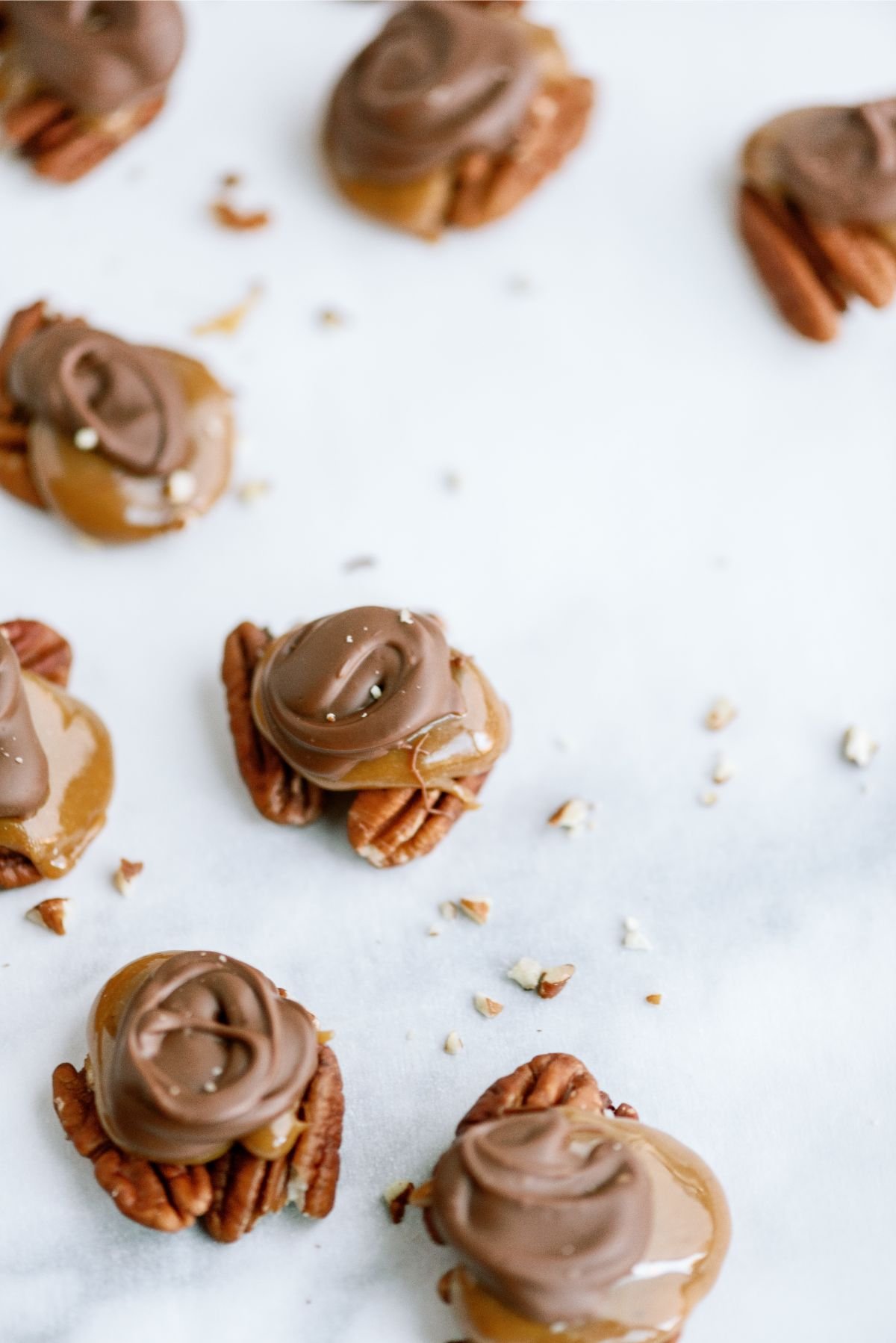 Chocolate Caramel Pecan Turtles on parchment paper