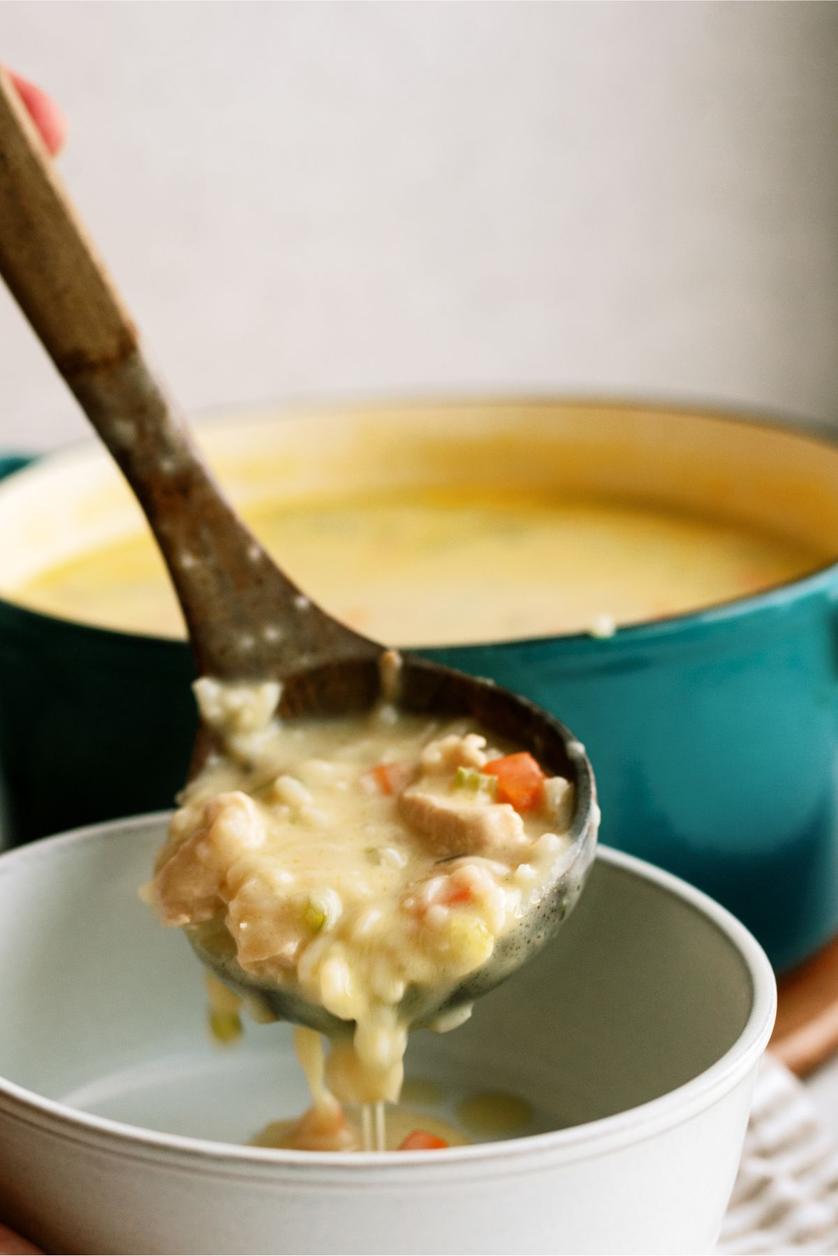 A ladle scooping a serving of Creamy Chicken and Wild Rice Soup into a bowl