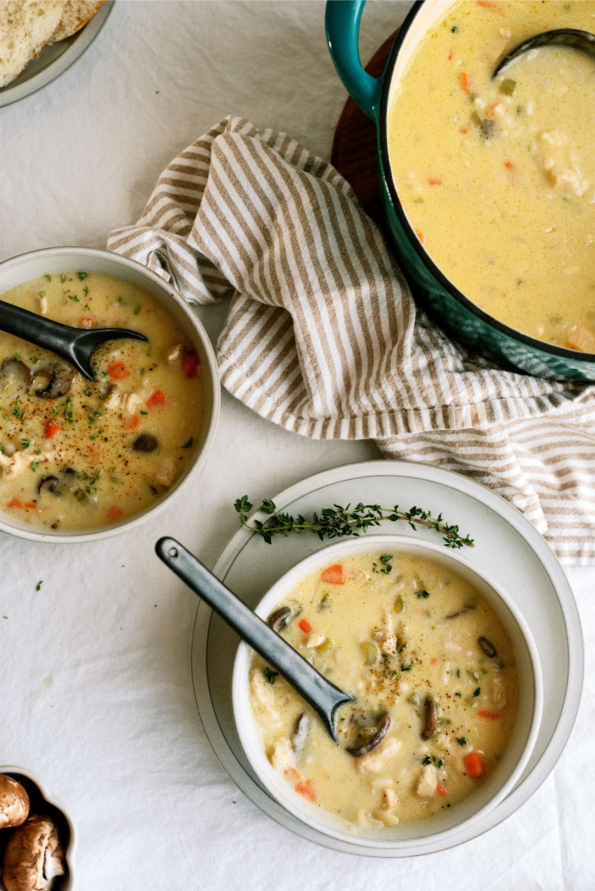 A pot and a bowl full of Creamy Chicken and Wild Rice Soup