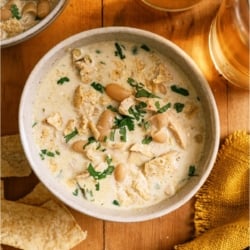 Top view of a bowl of Creamy White Chicken Chili with tortilla chips on the side.