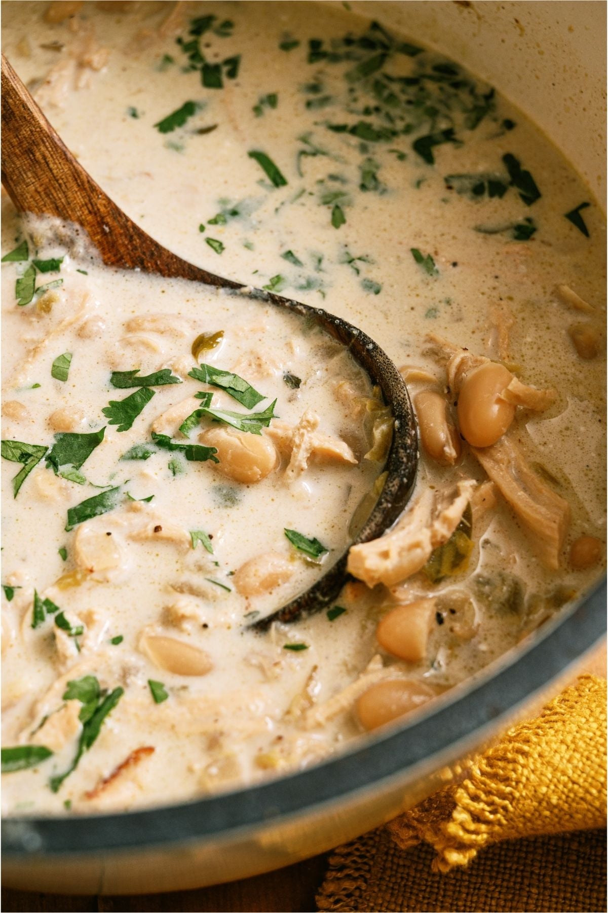 Close up of a scoop of Creamy White Chicken Chili in the pot.