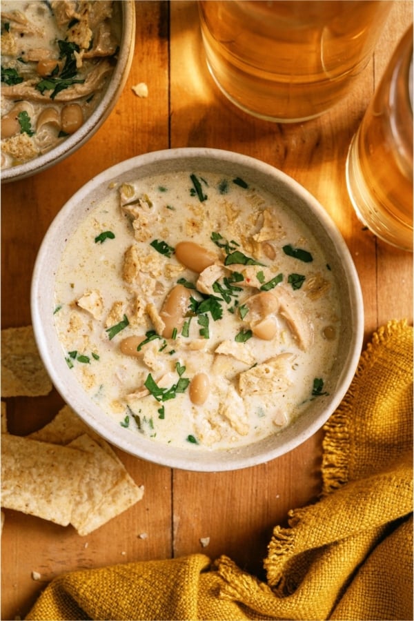 Top view of a bowl of Creamy White Chicken Chili with tortilla chips on the side.