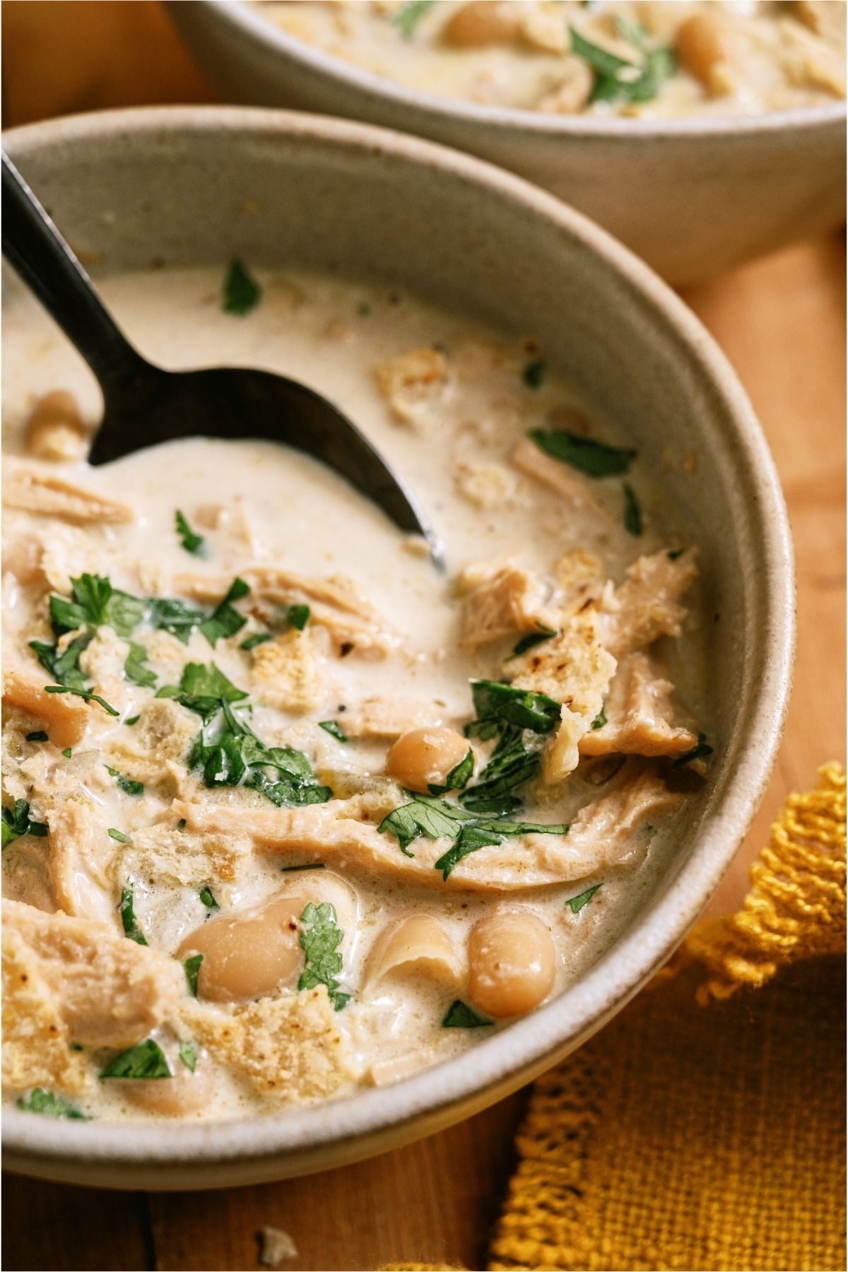 Close up of a bowl of Creamy White Chicken Chili with a spoon.