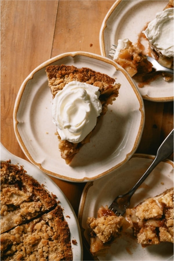 Top view of a slice of Dutch Apple Pie on a plate topped with whip cream.