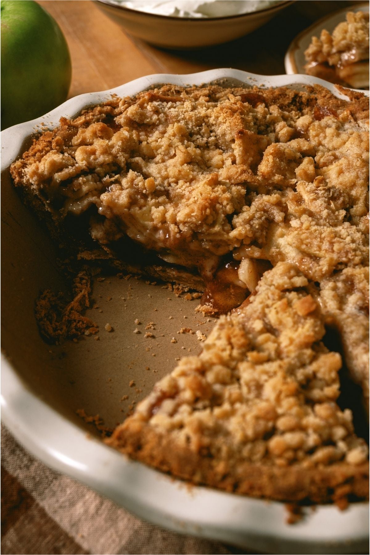Dutch Apple Pie in a pie dish with several slices missing.