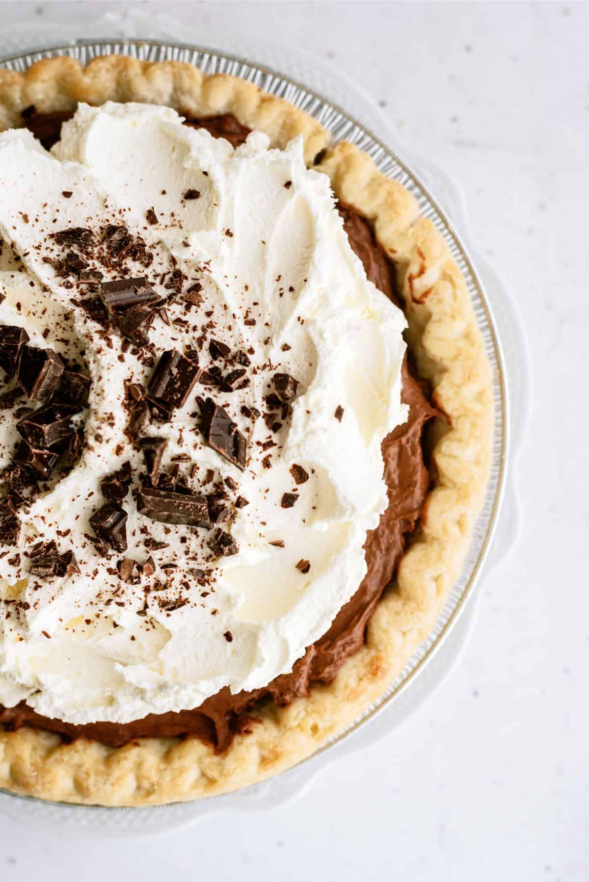 Close up of the top view of a Chocolate Cream Pie topped with whip cream and chocolate shavings.