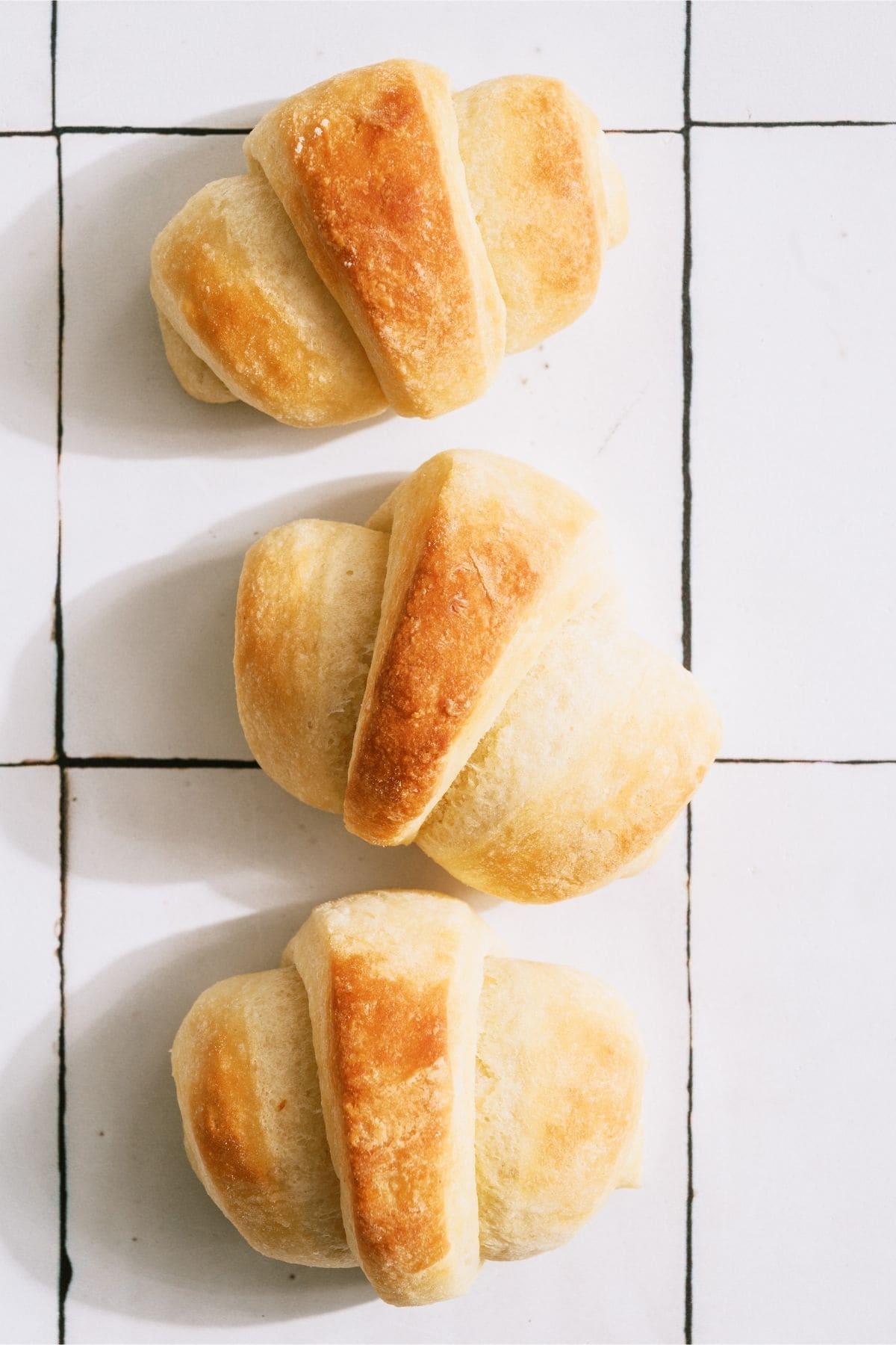 3 Easy Homemade Rolls lined up on a white backgroud.