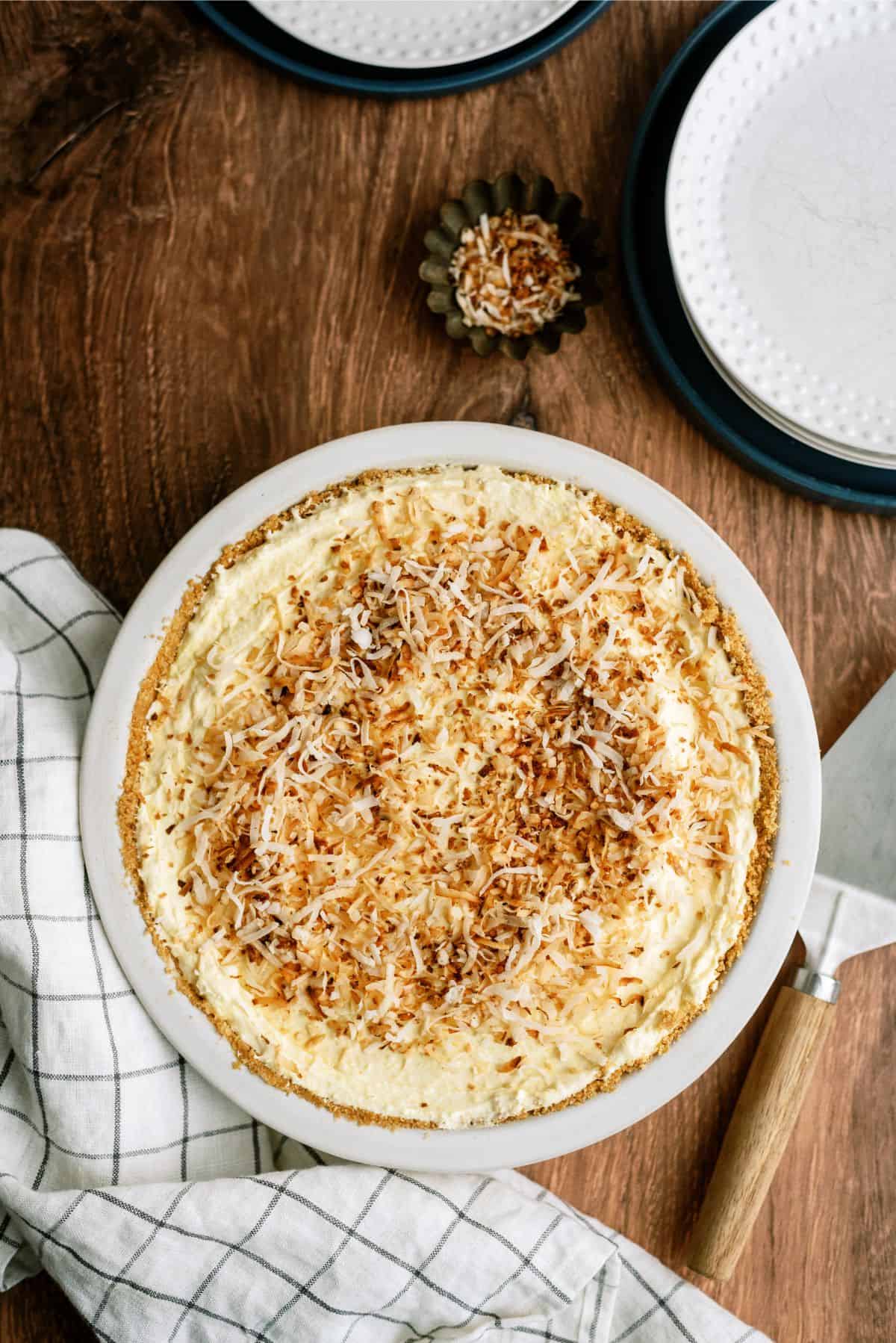Top view of No Bake Coconut Cream Pie on a countertop with a small bowl of toasted coconut next to it.