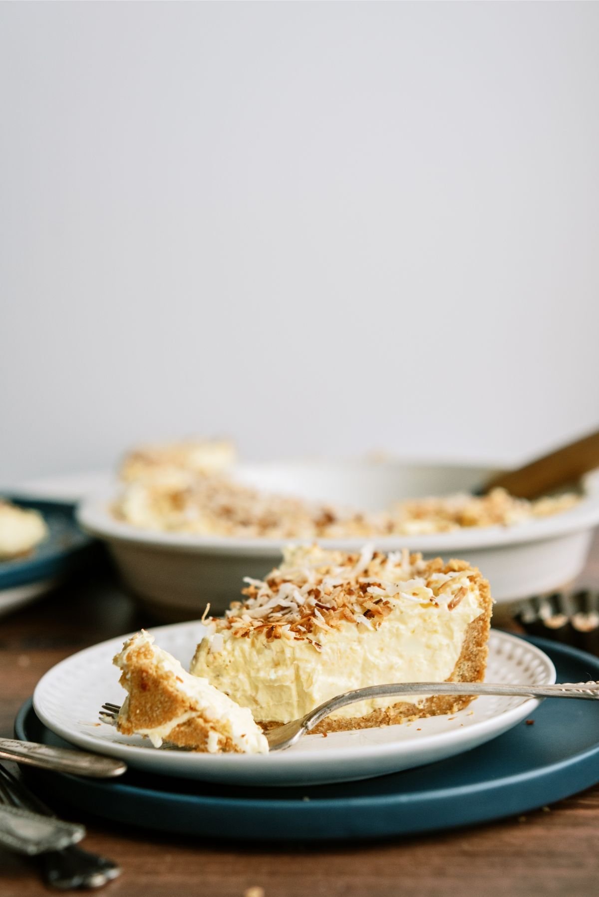 Side view of a slice of No Bake Coconut Cream Pie on a plate with a fork