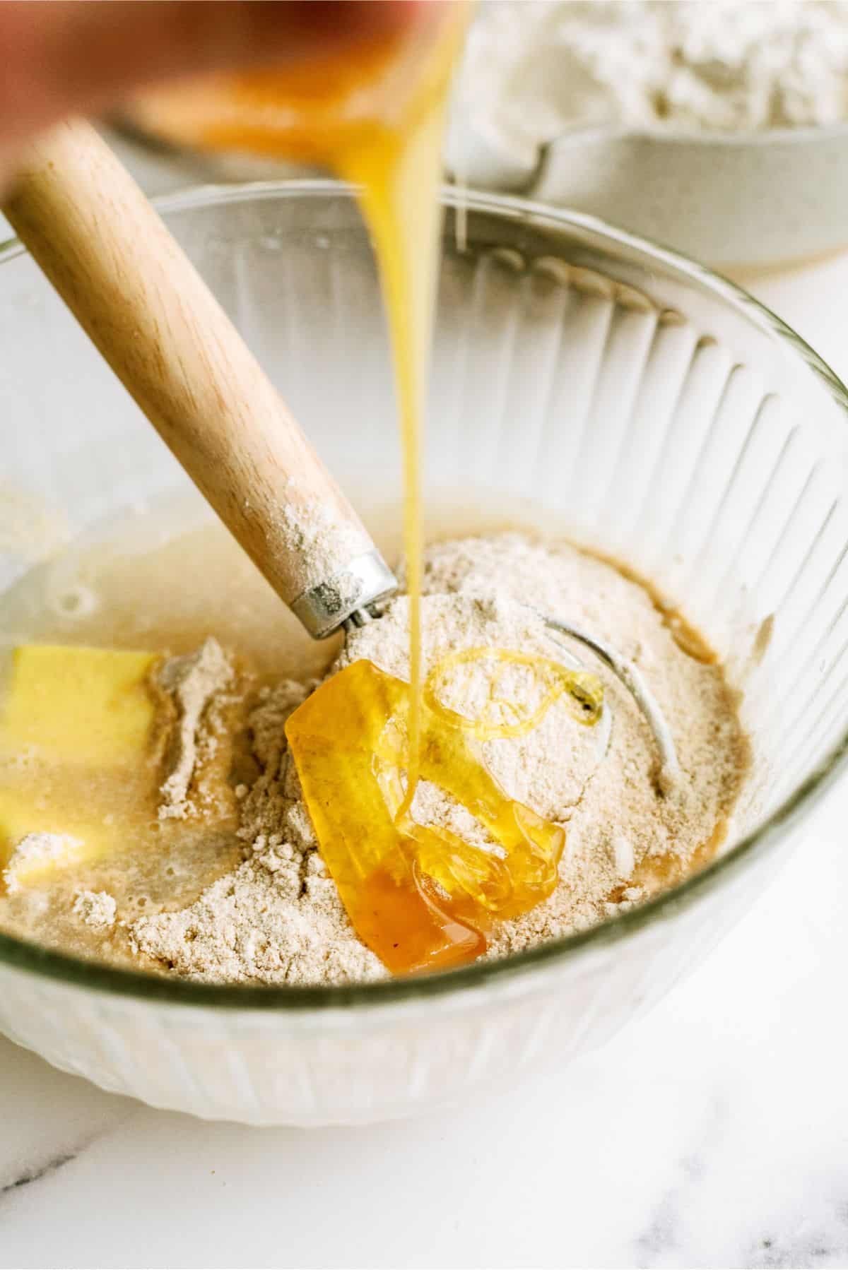 Adding honey to No Knead Honey Wheat Dinner Rolls dough