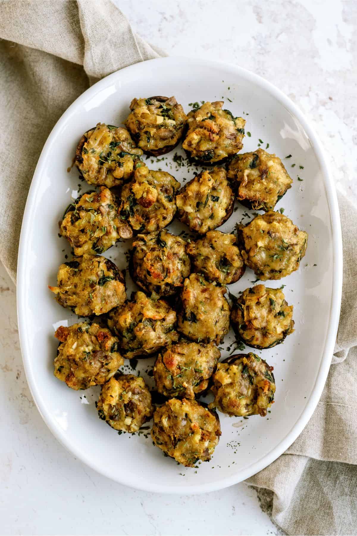 A serving plate full of Parmesan Spinach Stuffed Mushrooms