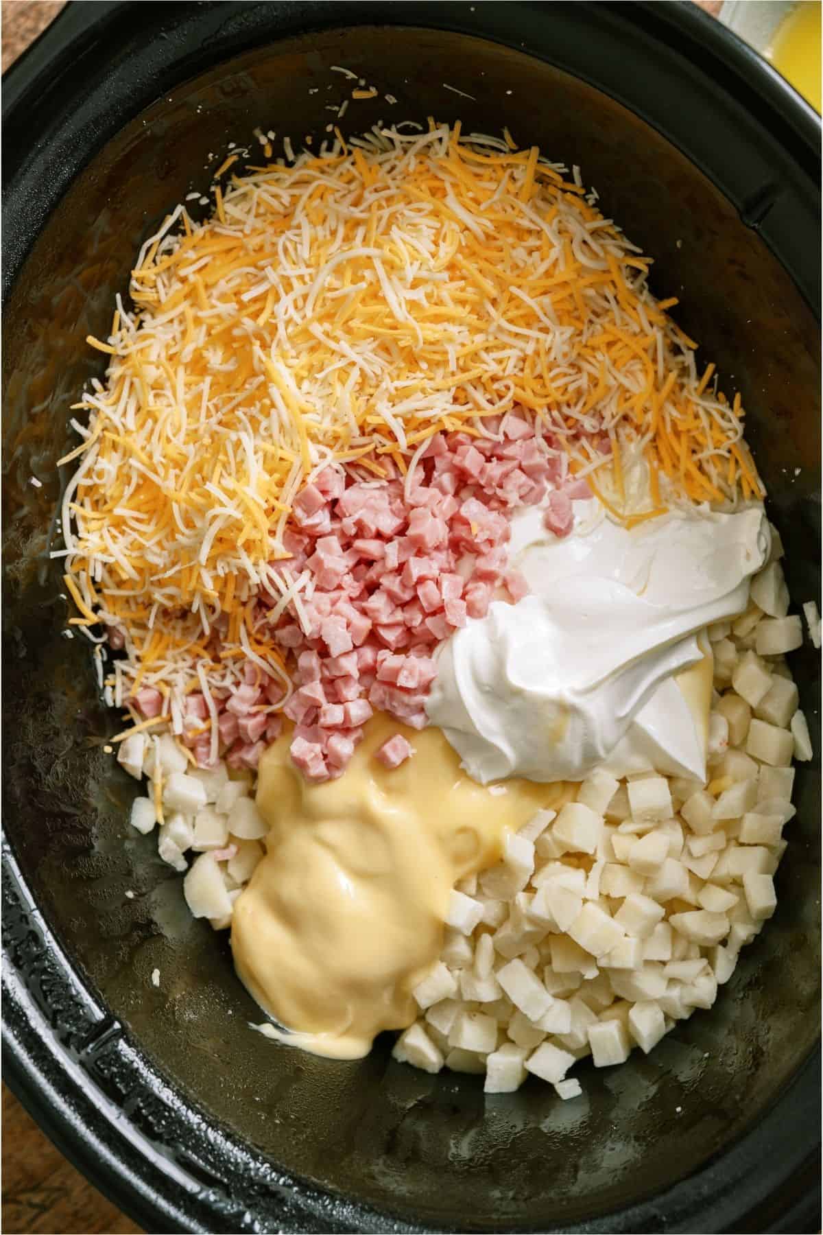 Potatoes, Ham, cheese, sour cream and soup in a slow cooker.