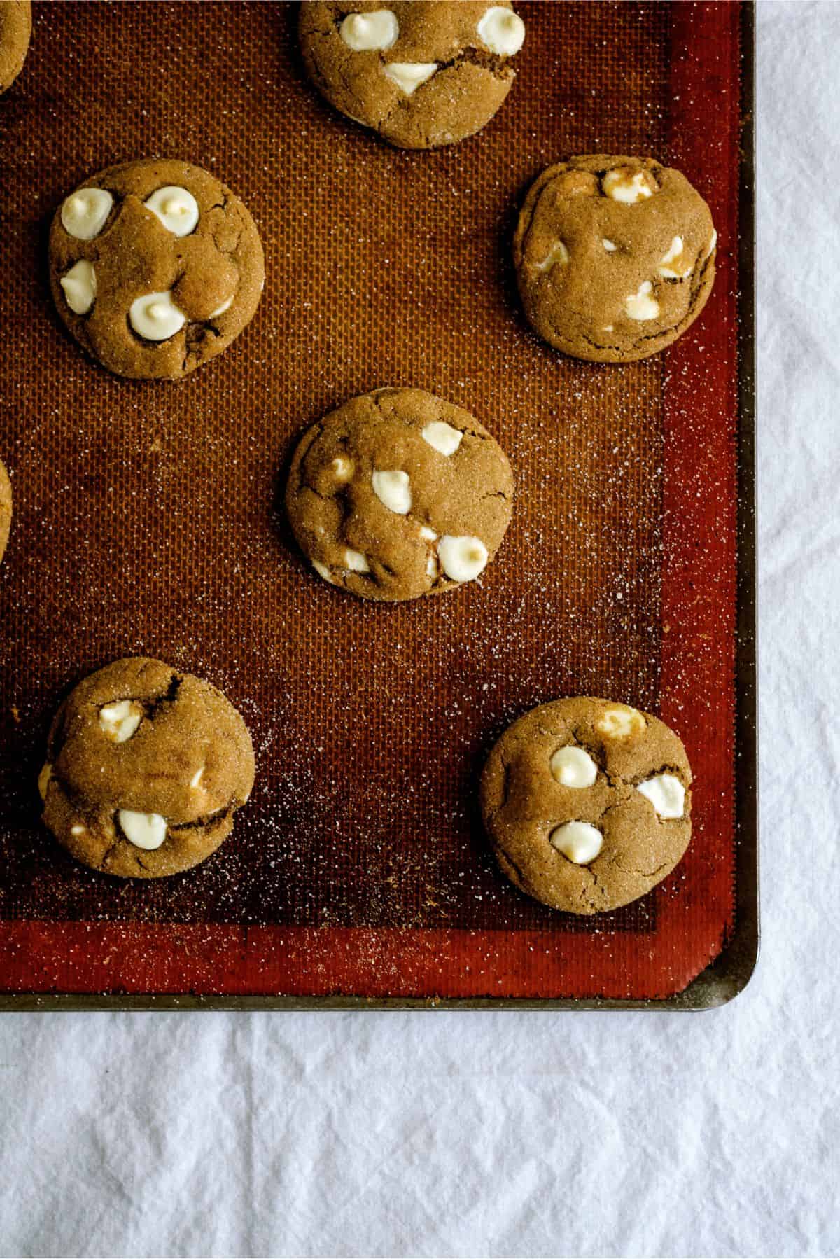 Top view of White Chocolate Chip Gingerbread Cookies on a baking sheet with a silicone liner.