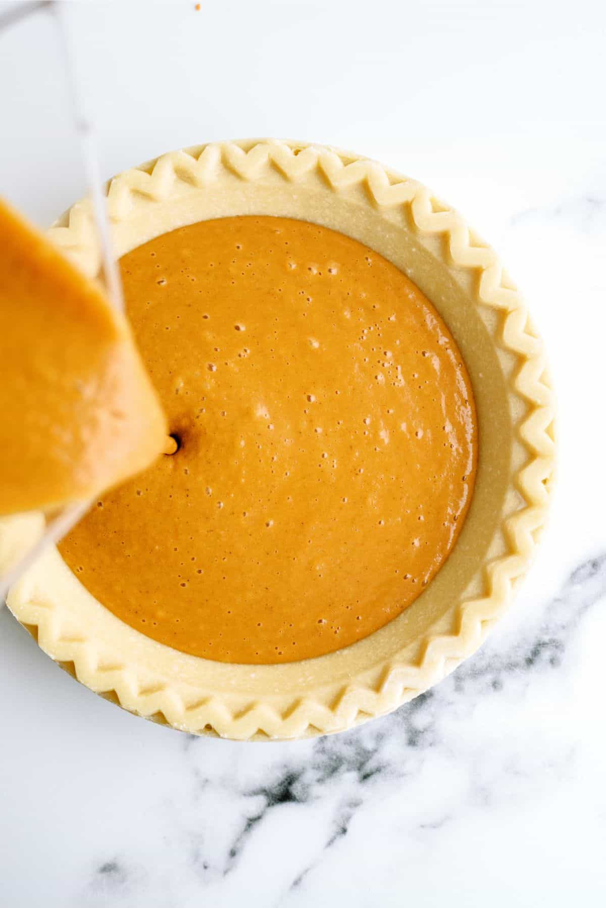 Pour sweet potato pie filling in pie crust