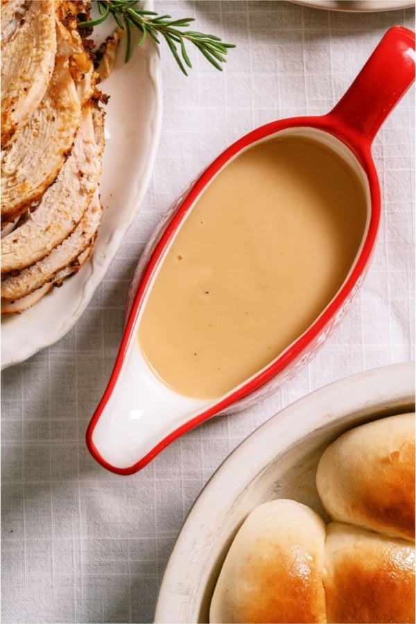 Top view of homemade Turkey Gravy in a red and white gravy boat.
