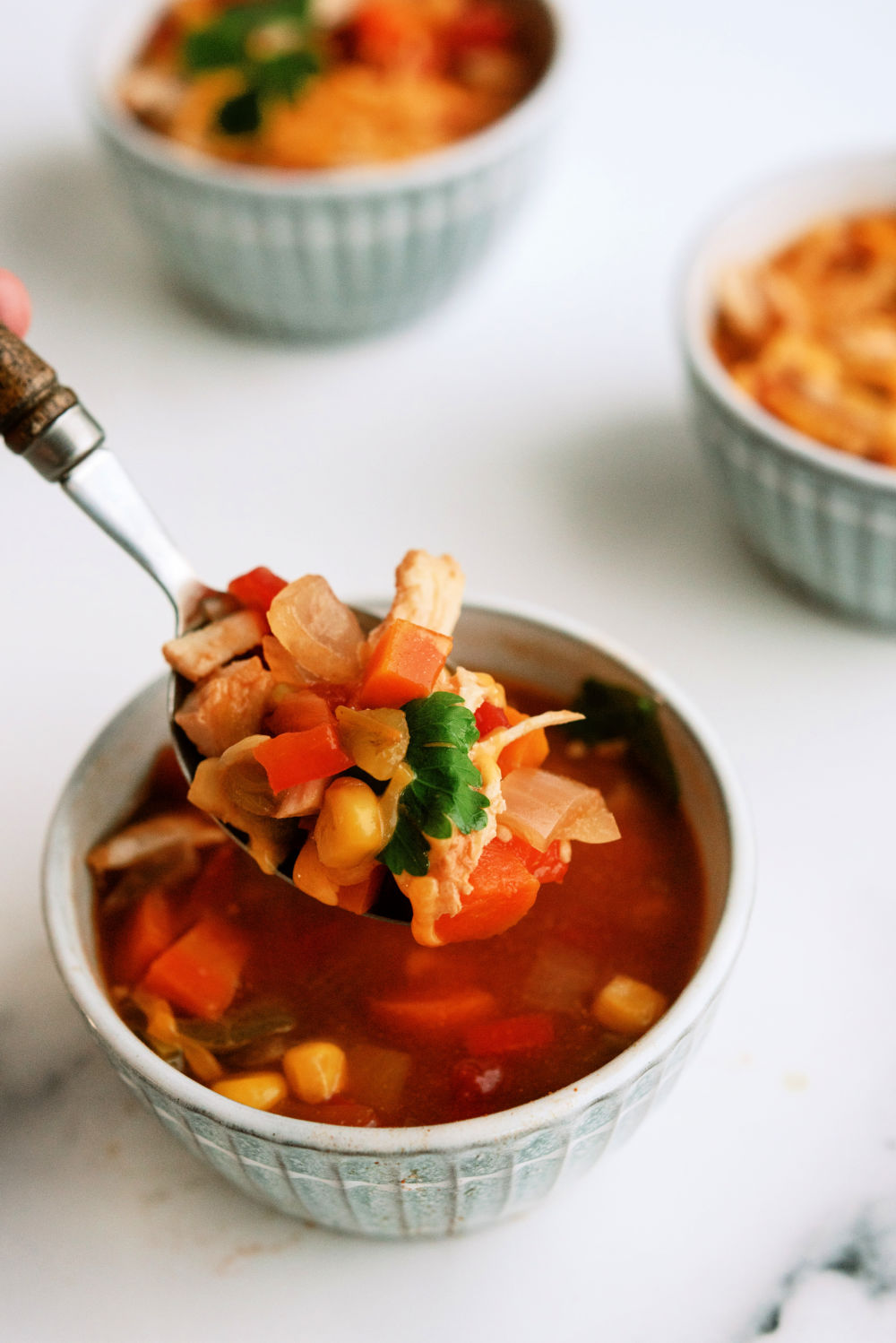 A spoonful of Slow Cooker BBQ Chicken Chili from a bowl