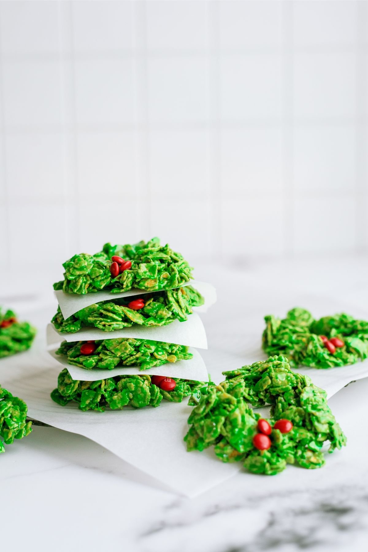 Cornflake Christmas Wreath Cookies stacked with wax paper