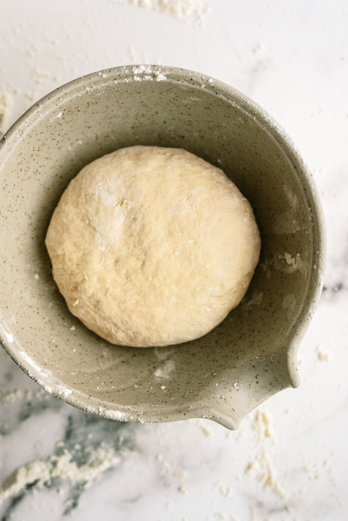 Pizza dough rising in mixing bowl