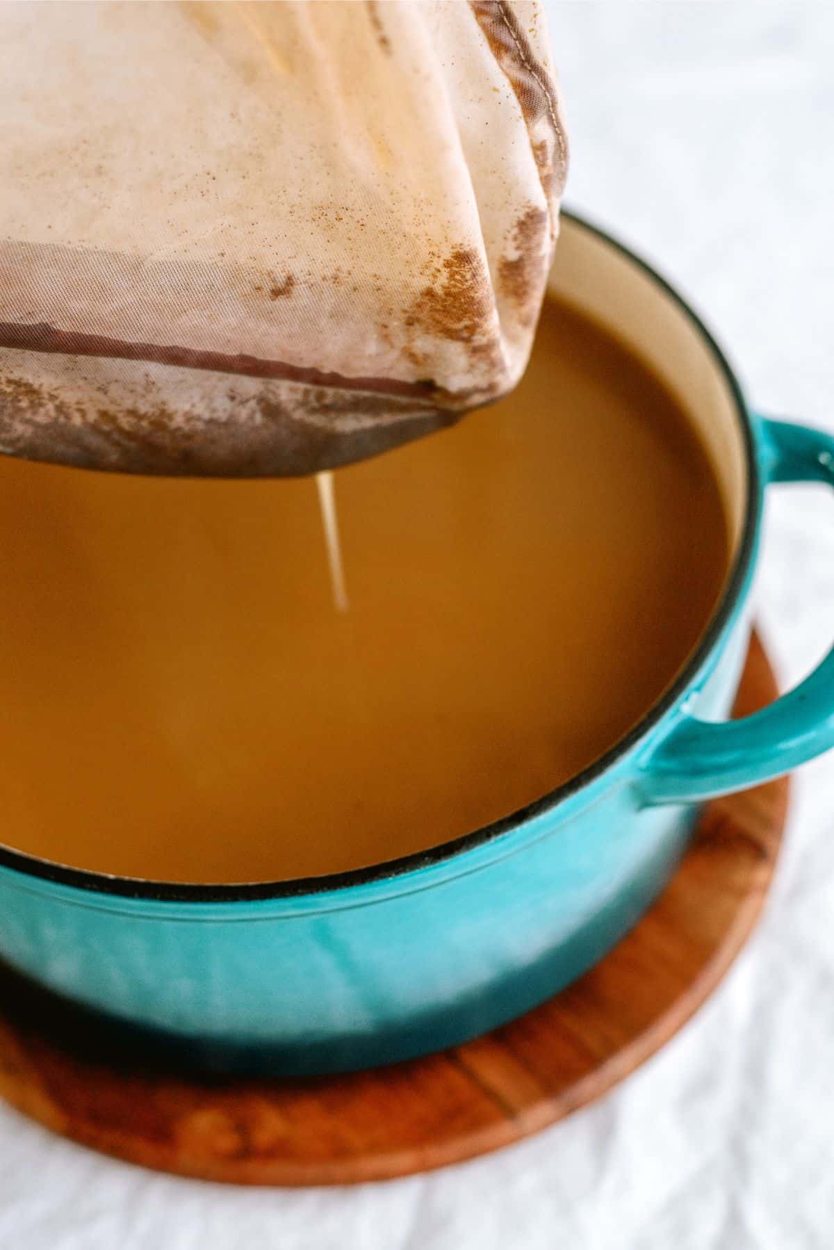 Squeezing the cider out of the cheesecloth into the stock pot