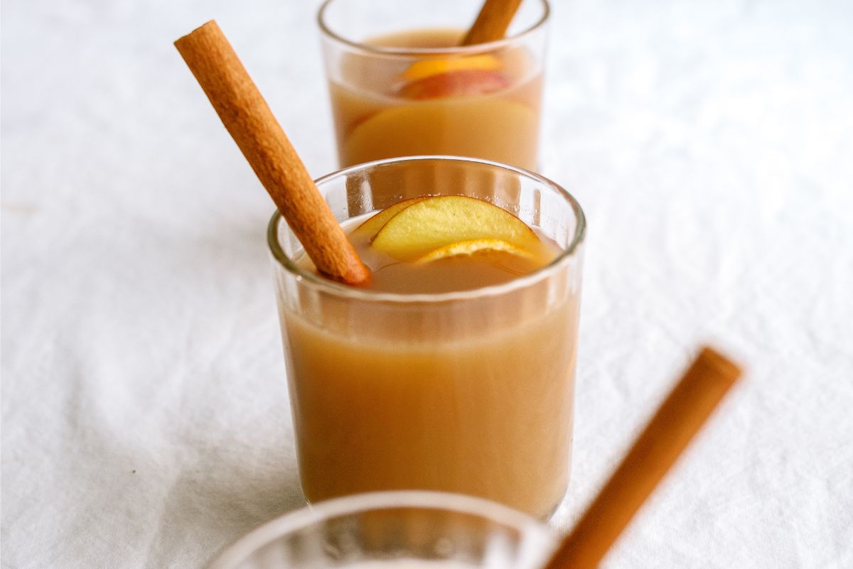 Close up of Grandma’s Warm Spiced Cider in a glass with a cinnamon stick