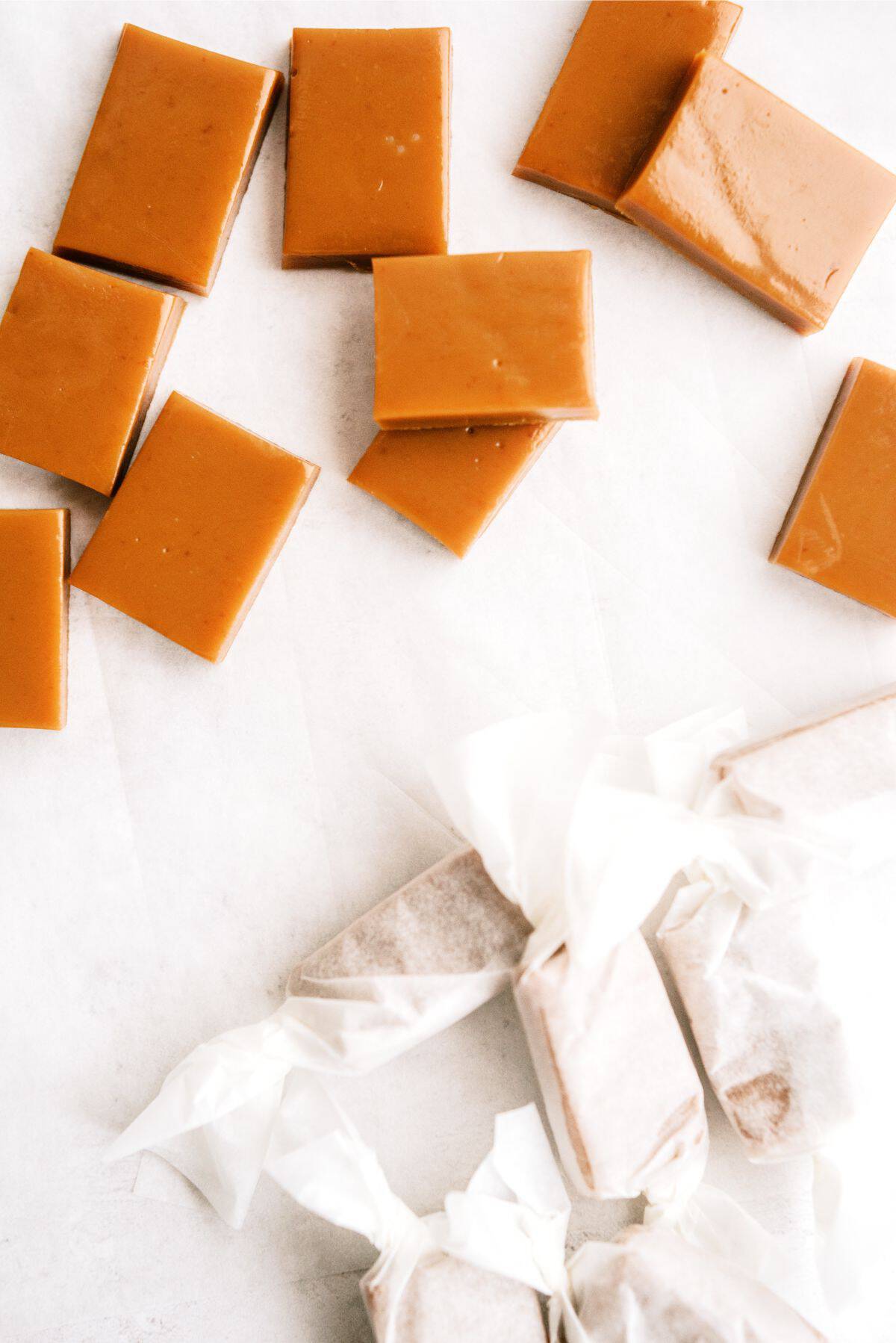 Homemade Caramels cut into rectangles with some wrapped in wax paper