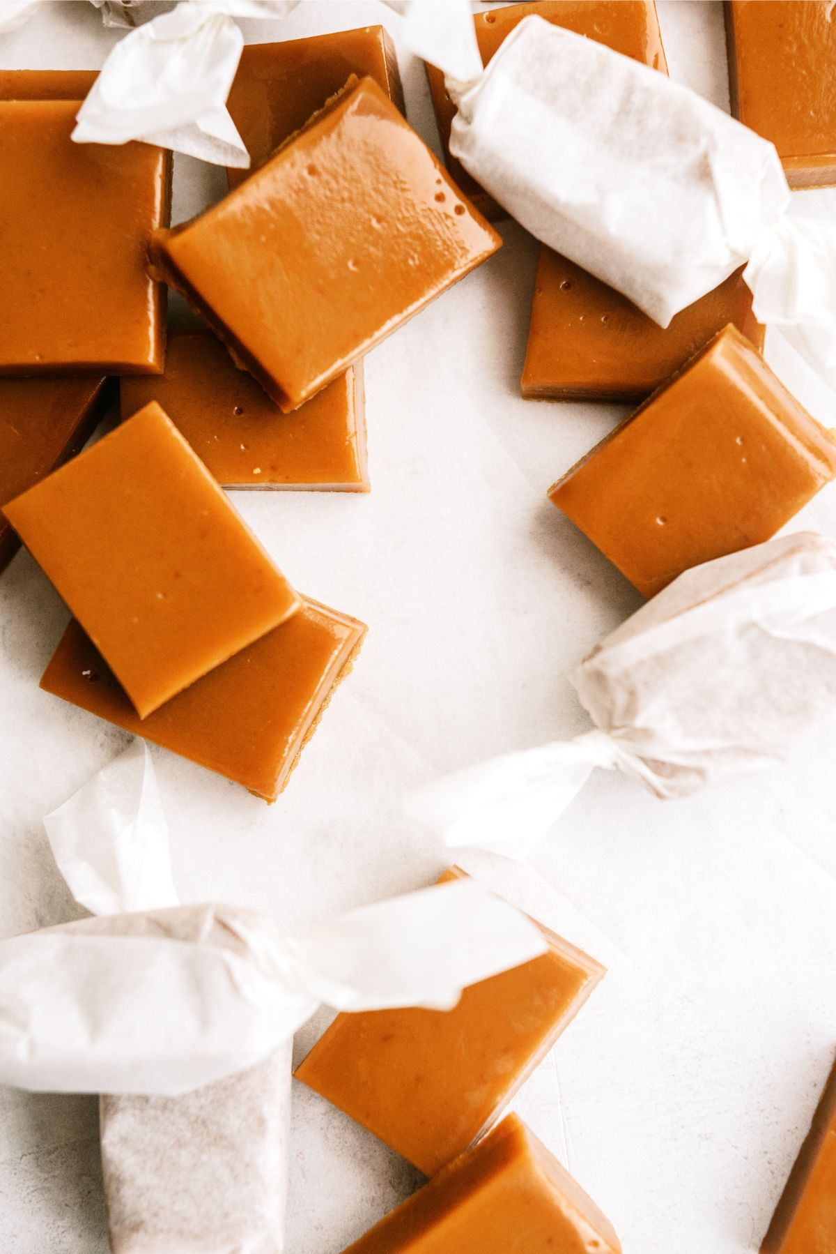 Homemade Caramels cut into rectangles with some wrapped in wax paper
