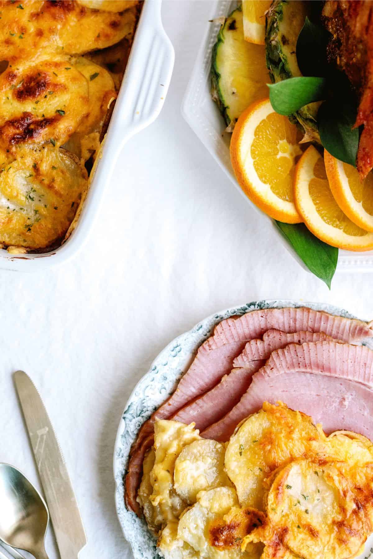 A plate with a serving of Homemade Scalloped Potatoes and Ham