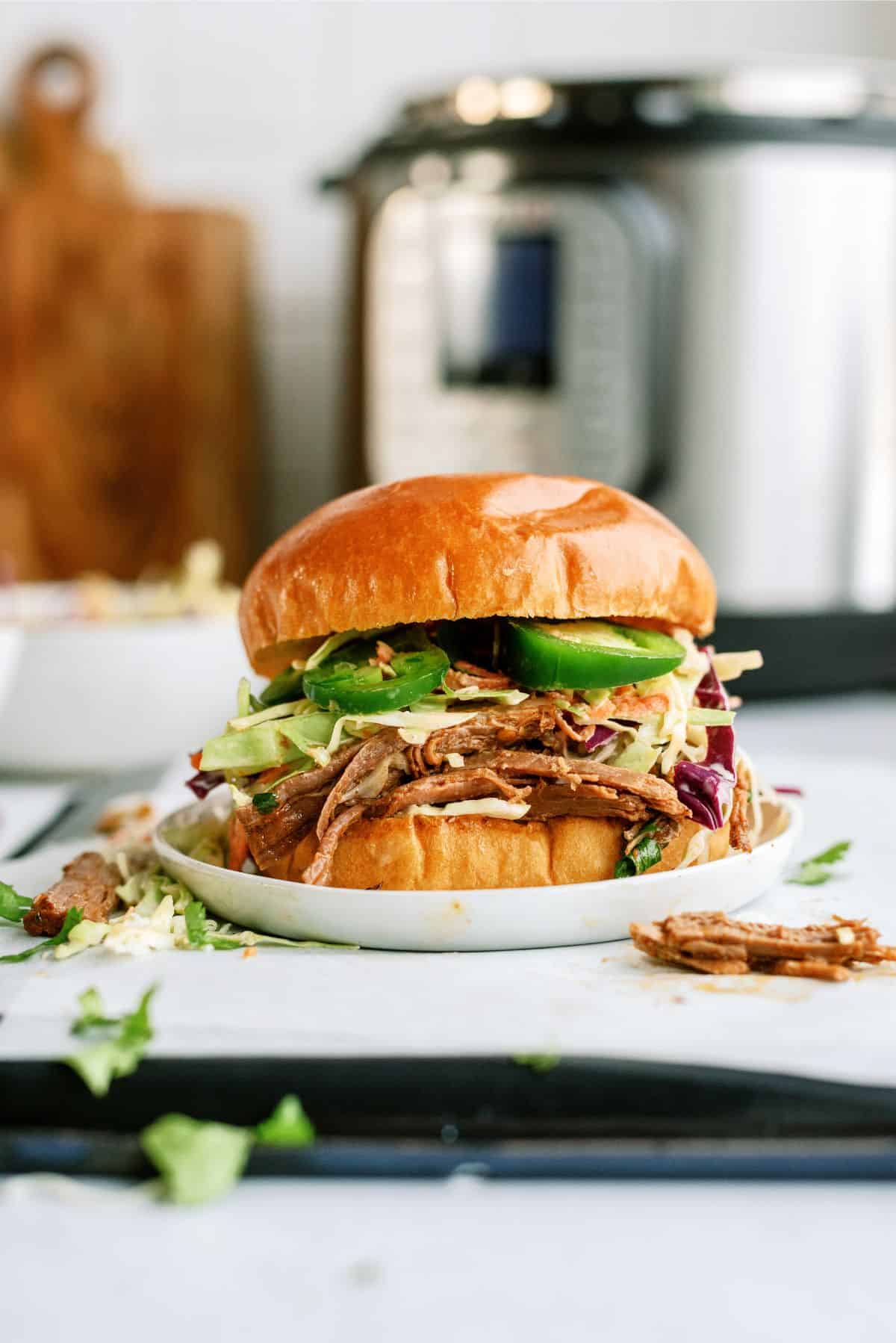 Instant Pot Southwest Shredded Beef Sandwich on a plate with an Instant Pot in the background